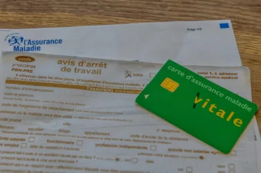 Une carte Vitale est posée sur un bulletin d'arrêt de travail.